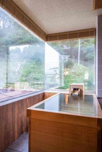 a large window in a room with a bath tub at Uesugi no Miyu Gotenmori in Nanyo