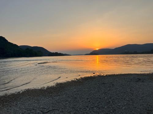 a sunset on the shore of a body of water at MemoriaMarci - Free Bikes, Danube Band & Pilis in Pilismarót