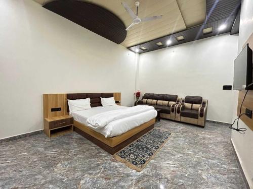1 dormitorio con 1 cama y 1 sofá en OYO Flagship Hotel Pranav Inn, en Faizābād