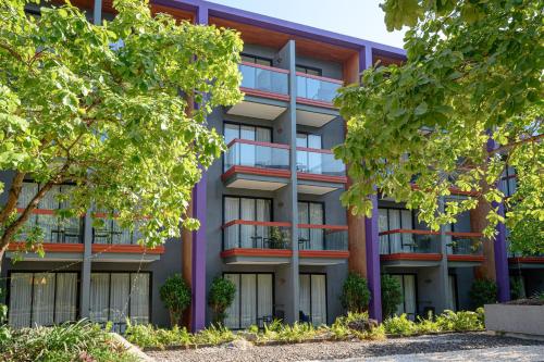 an apartment building with trees in front of it at Holiday Inn Express Phuket Patong Beach Central by IHG in Patong Beach