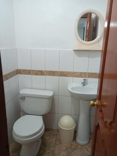 a bathroom with a toilet and a sink at Hotel TIKA AYNA Cerca a la plaza de Armas CUSCO in Cusco