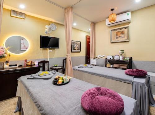 um quarto grande com duas camas e uma televisão em Hanoi Rose Flower Hotel & Spa em Hanói