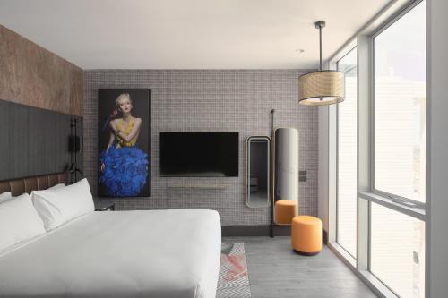 um quarto com uma cama e uma televisão de ecrã plano em The Motley Hotel em Melbourne
