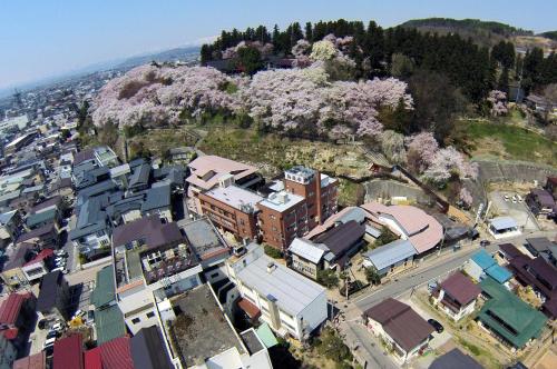 南陽市にある上杉の御湯 御殿守の桜の木がある街の航空写真