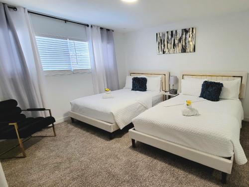 a bedroom with two beds and a chair and a window at Vegas best stay in Las Vegas