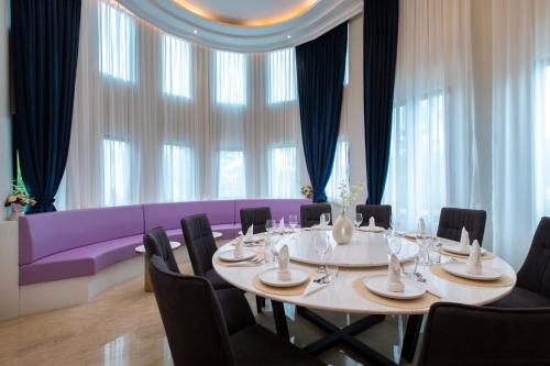 a dining room with a table and a purple couch at Cameron Lavender Mansion by PLAY in Brinchang