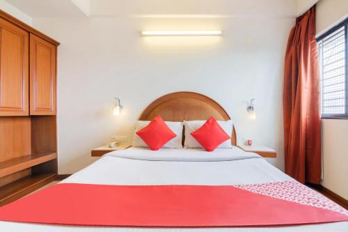 ein Schlafzimmer mit einem großen Bett mit roten Kissen in der Unterkunft OYO Hotel Sunil Residency in Bangalore