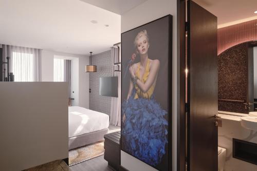 um quarto com uma pintura de uma mulher na parede em The Motley Hotel em Melbourne