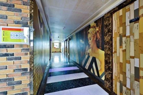 a hallway with a painting of a woman on the wall at Geoje King motel in Geoje 