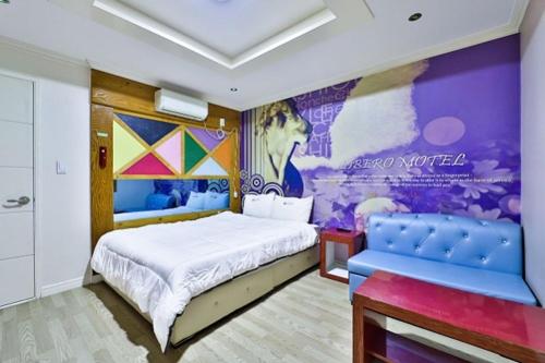 a bedroom with a king sized bed and a mural at Geoje King motel in Geoje 