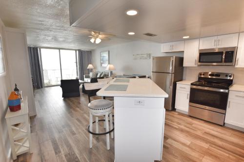una cucina e un soggiorno con armadi bianchi e tavolo di 0903 Waters Edge Resort condo a Myrtle Beach
