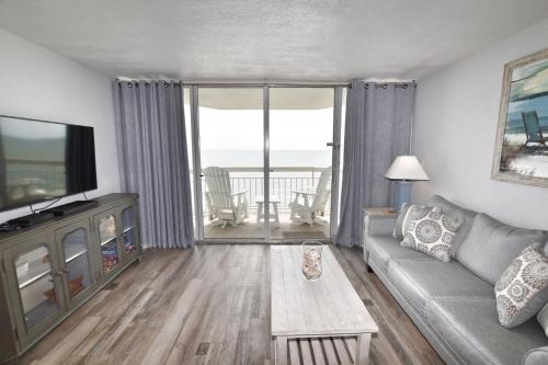 un soggiorno con divano, TV e tavolo di 0903 Waters Edge Resort condo a Myrtle Beach