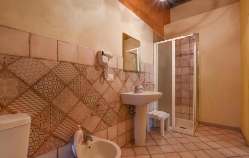 uma casa de banho com um lavatório, um WC e um espelho. em Amazing Home In Santa Venerina With Wifi em Santa Venerina