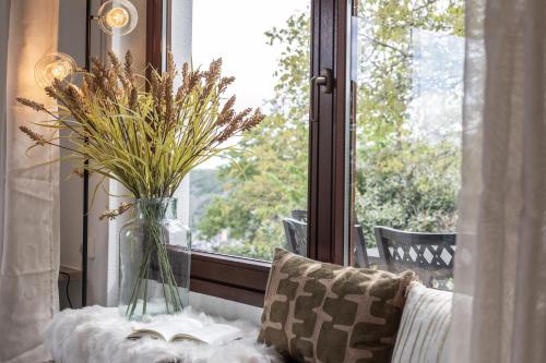 a vase of flowers sitting on a table next to a window at Cozy II Luxuriös Moselview Terrasse Garten NETFLIX in Leiwen