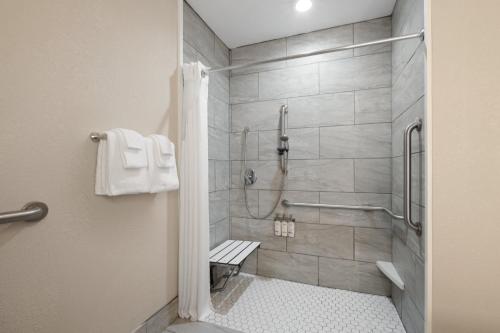 a bathroom with a shower with a bench in it at Holiday Inn Express & Suites Sebring, an IHG Hotel in Sebring