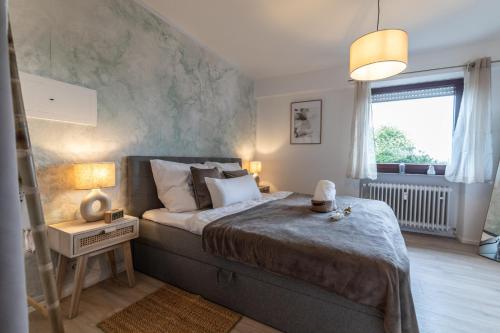 a bedroom with a large bed and a window at Cozy II Luxuriös Moselview Terrasse Garten NETFLIX in Leiwen