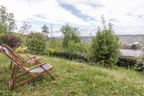 two wooden chairs sitting in a field of grass at Cozy II Luxuriös Moselview Terrasse Garten NETFLIX in Leiwen