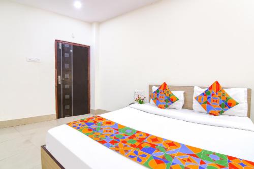 1 dormitorio con 2 camas y almohadas coloridas en FabExpress Vhyom Sky Palace, en Calcuta