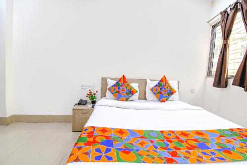 sypialnia z łóżkiem z kolorowym kocem w obiekcie FabExpress Vhyom Sky Palace w mieście Kolkata