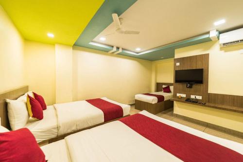 a hotel room with two beds and a flat screen tv at SAU Residency in Kanchipuram