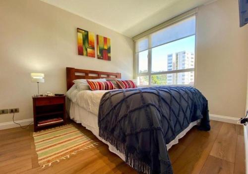 1 dormitorio con cama y ventana grande en Hermoso departamento a pasos de UdeC, en Concepción