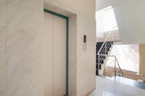 una puerta giratoria en un pasillo con una escalera en Collection O Goodwill Hotel, en Jammu