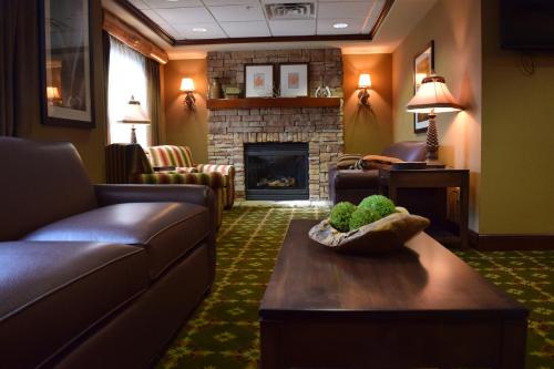 a living room with a couch and a fireplace at Holiday Inn Express Hocking Hills-Logan by IHG in Logan