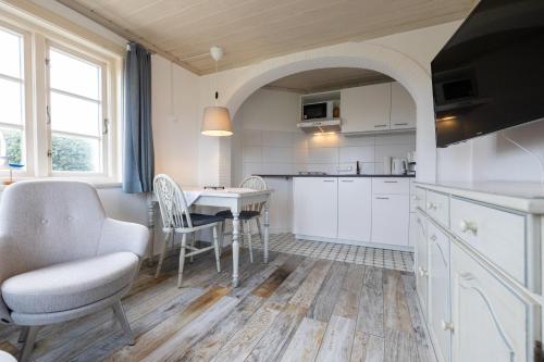 a kitchen and dining room with a table and chairs at Haus Amanda in Norddorf