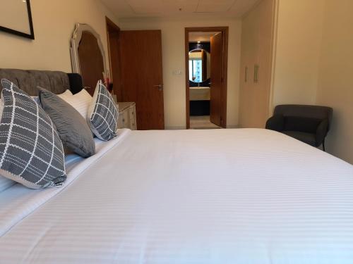 a bedroom with a large white bed with pillows at Trinity Holiday Homes - Sheikh Zayed Road Near to Financial Center Metro Station in Dubai