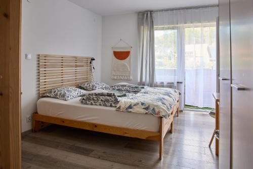 um quarto com uma cama e uma grande janela em Pokoje Gościnne "SOSENKA" em Cisna