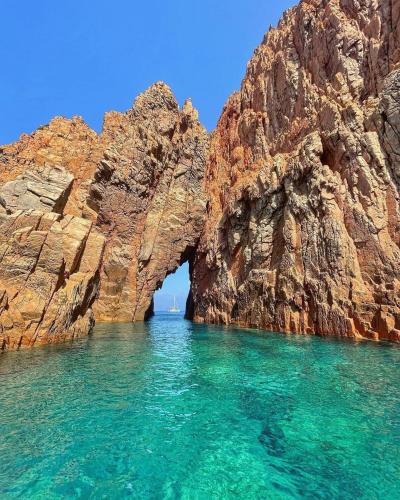 an arch in a rock formation in the water at Casa Versini in Balogna