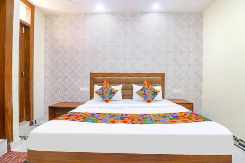 um quarto com uma grande cama branca com almofadas coloridas em FabHotel Starlight em Nova Deli