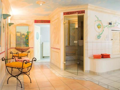 ein Bad mit einer Dusche sowie einem Tisch und Stühlen in der Unterkunft Wellnesshotel Sanct Bernhard in Bad Ditzenbach