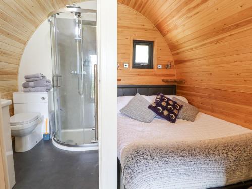 a bedroom with a shower and a bed in a room at Luna Holiday Pod in Shrewsbury