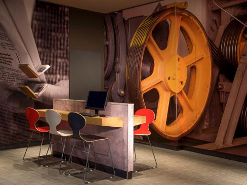 a room with a desk with chairs and a large wheel at ibis Bremen City in Bremen