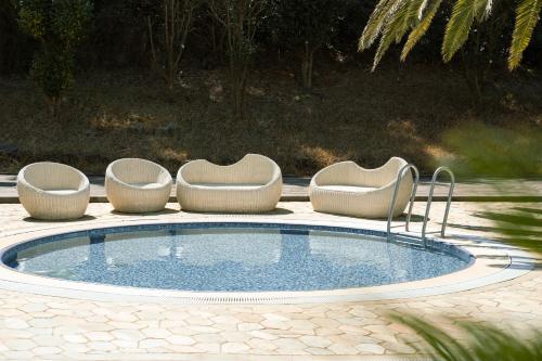 - une piscine avec 3 chaises et une table dans l'établissement Phoenix Island, à Seogwipo