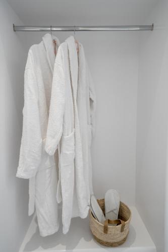 a group of towels hanging on a rack with a basket at Halari Junior Suite in Vourvoúlos
