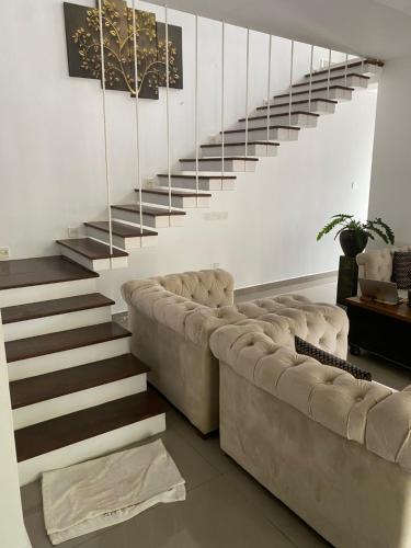 a living room with a couch and a staircase at Hotel Cloud 9 Negombo in Negombo