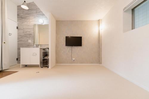 a living room with a tv on a wall at Flower Base Lily House in Fukuoka