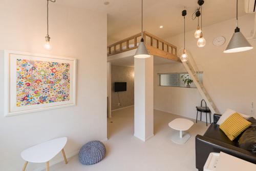 a living room with a couch and a painting on the wall at Flower Base Lily House in Fukuoka