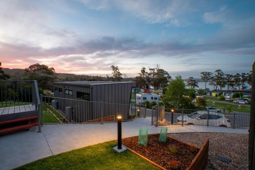 Tasman Holiday Parks - St Helens في سانت هيلينز: منزل به سياج ومقعد في ساحة