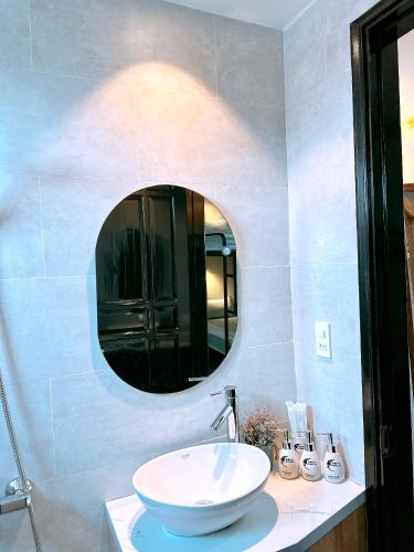 a bathroom with a white sink and a mirror at Moon Homestay in Thôn Kim Long (1)