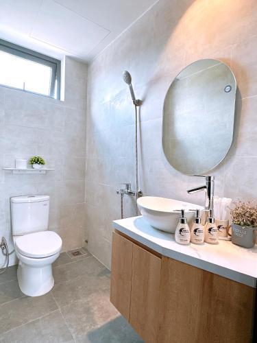 a bathroom with a toilet and a sink and a mirror at Moon Homestay in Thôn Kim Long (1)