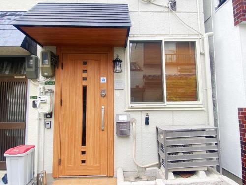 a house with a wooden door and a window at 芋ノ宿ー大正 in Osaka