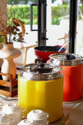 a table with three jars filled with different colored liquids at Niranapa Boutique Resort in Kata Beach