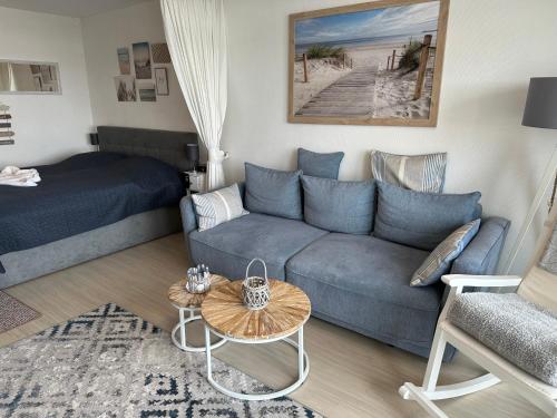a living room with a couch and a bed at Wohnung Südstrand Glück in Fehmarn