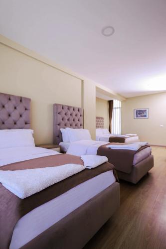 a row of beds sitting in a room at Hotel Frojd - Beach Front Resort in Shëngjin