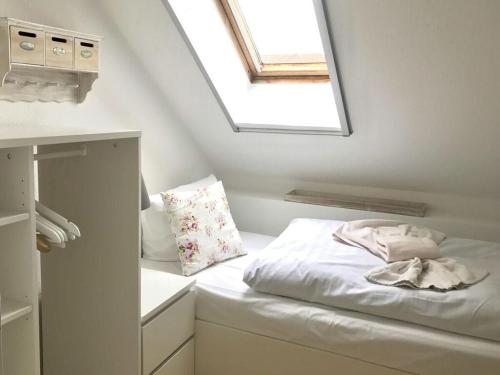 a small bedroom with a bed with a skylight at Zingstrose Comfortable holiday residence in Zingst