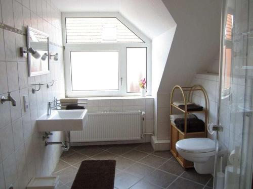 a bathroom with a sink and a toilet and a window at de Boer Comfortable holiday residence in Jever