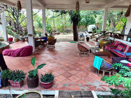 an outdoor patio with chairs and tables and plants at Jungle House Kep in Kep